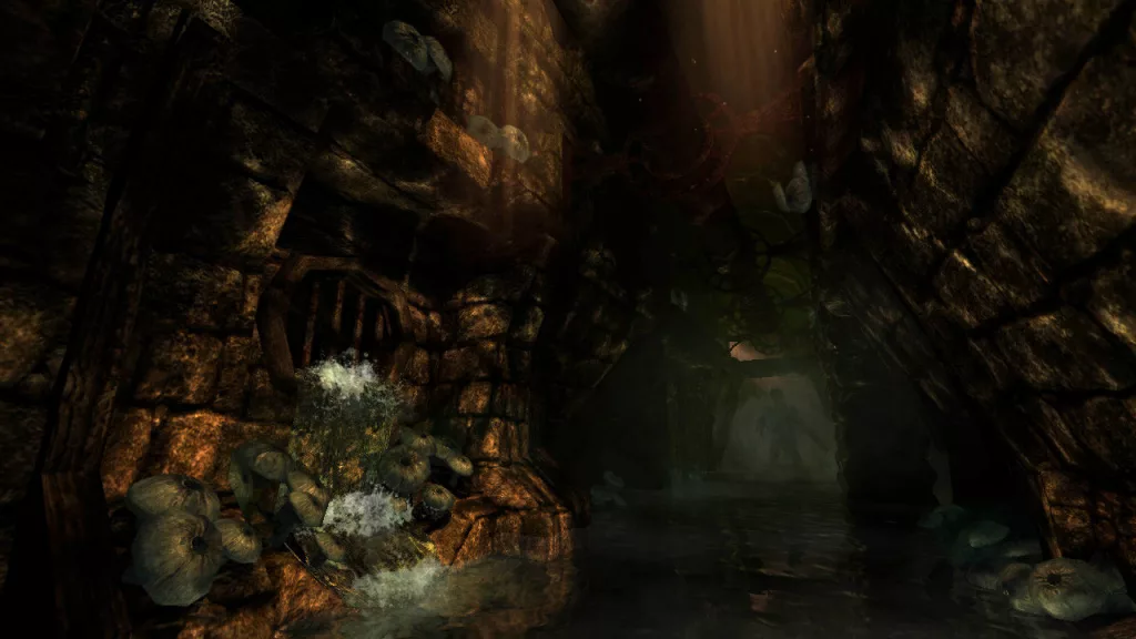 What is Amnesia: The Dark Descent? A dark and damp cavern with a small waterfall and a glimpse of light in the distance in Amnesia: The Dark Descent.