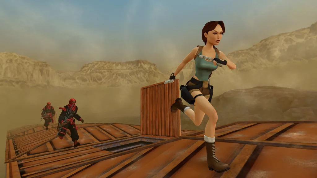 Lara Croft sprints across a moving train in a desert landscape, pursued by armed enemies in Tomb Raider IV-VI Remastered.