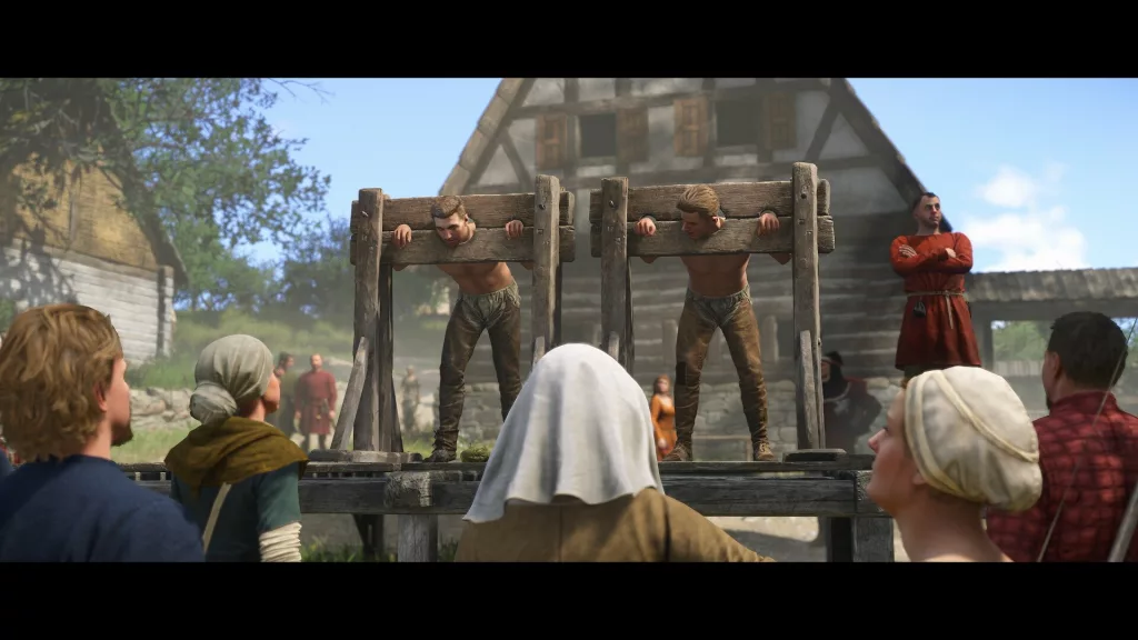 Two men locked in wooden stocks in a medieval village, surrounded by townspeople observing their punishment in Kingdom Come: Deliverance 2.