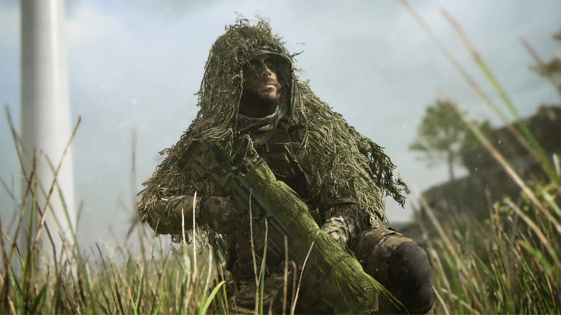 A close-up, dramatic shot of a soldier wearing a heavy ghillie suit and face paint, kneeling in tall grass with his sniper rifle, set against a blurred, slightly hazy background with a wind turbine.