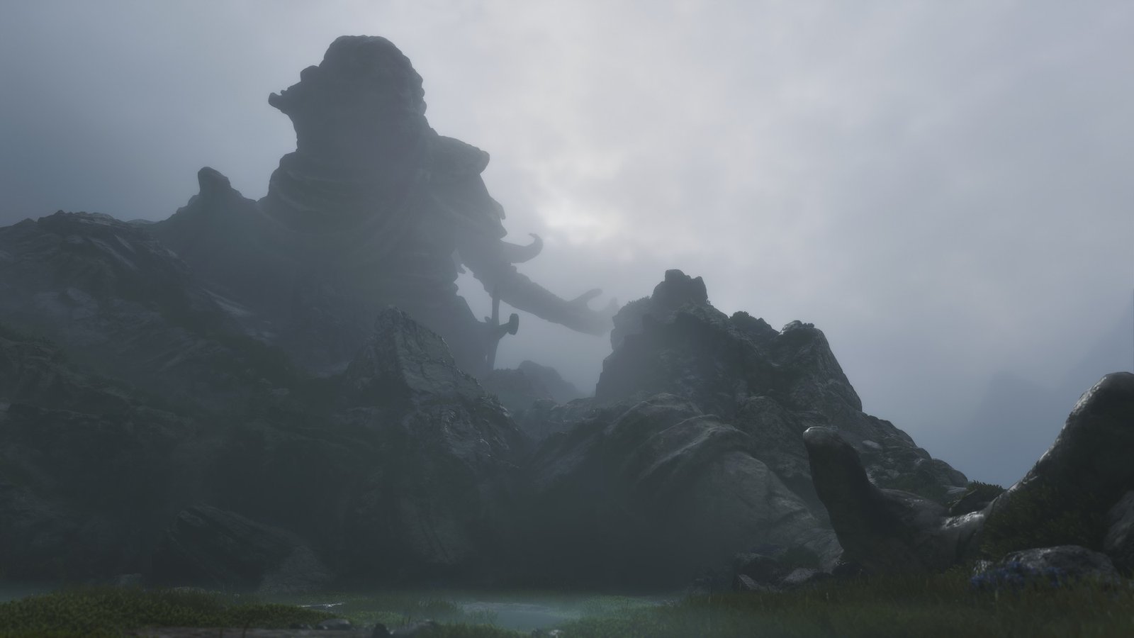 Fable: Wraithmarsh statue Fable screenshot: a giant broken statue looms out of the fog above rocky marshland in Wraithmarsh