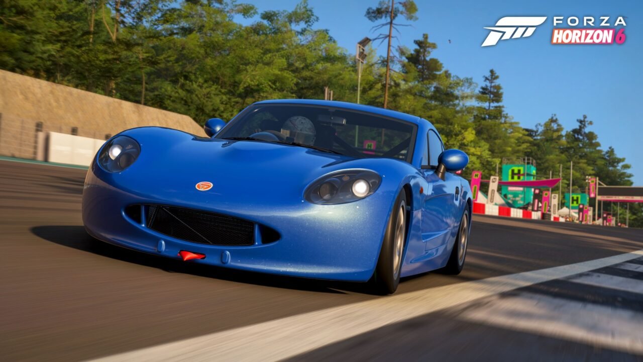Forza Horizon 6 screenshot: a blue 2019 Ginetta G40 Junior racing along a tree-lined circuit in Horizon Japan