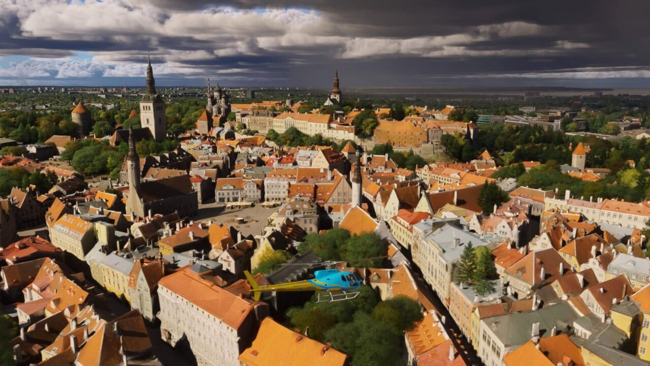 Microsoft Flight Simulator 2024 screenshot: an aerial view of Tallinn's medieval Old Town with red roofs, church spires and city walls