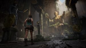 Lara Croft standing before a large golden statue in a ruined hall
